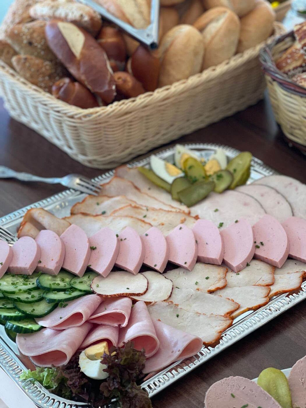 Frischer Brotkorb mit Aufschnitt und Beilagen