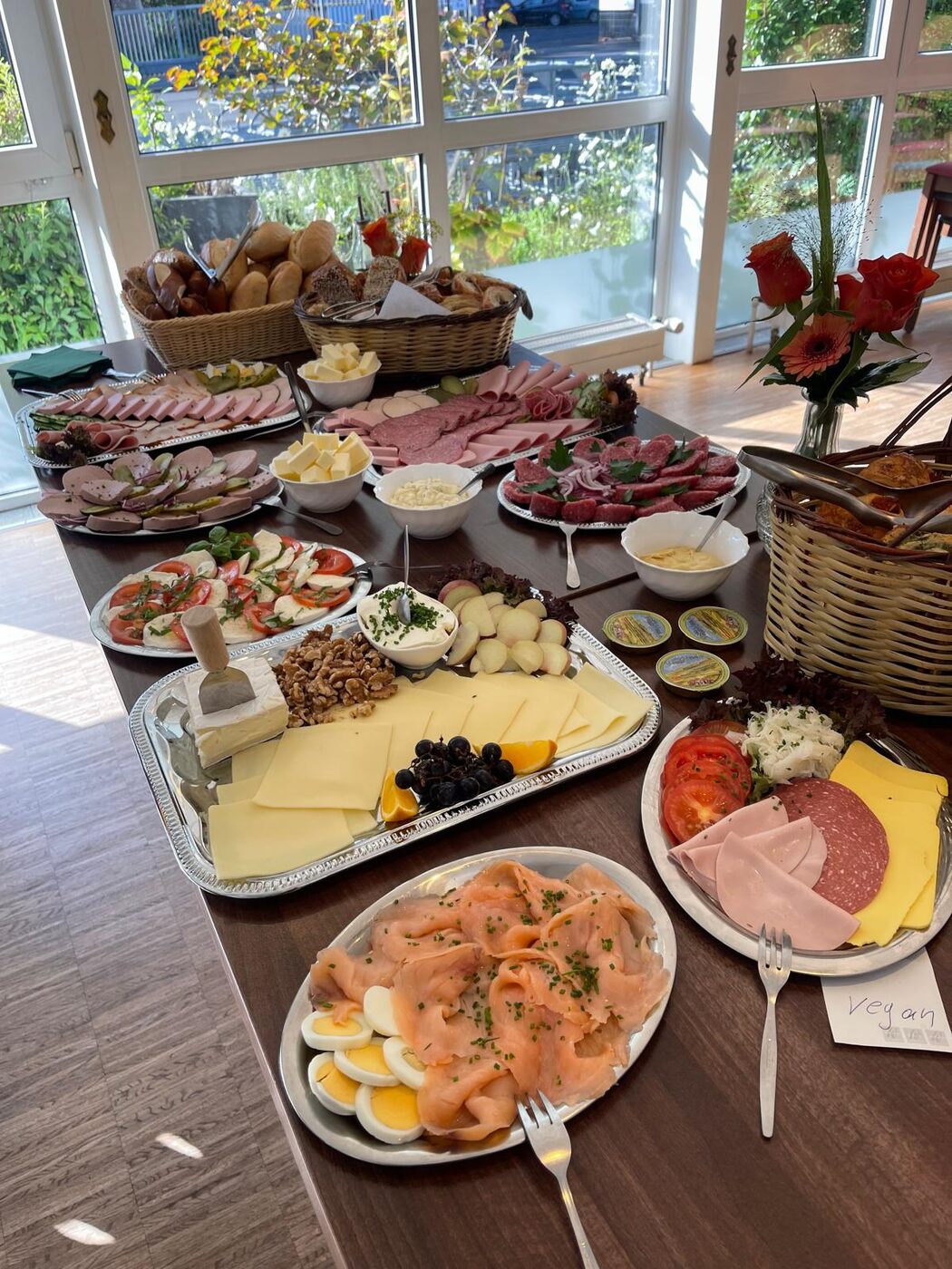 Reich gedecktes Buffet im sonnendurchfluteten Gastraum