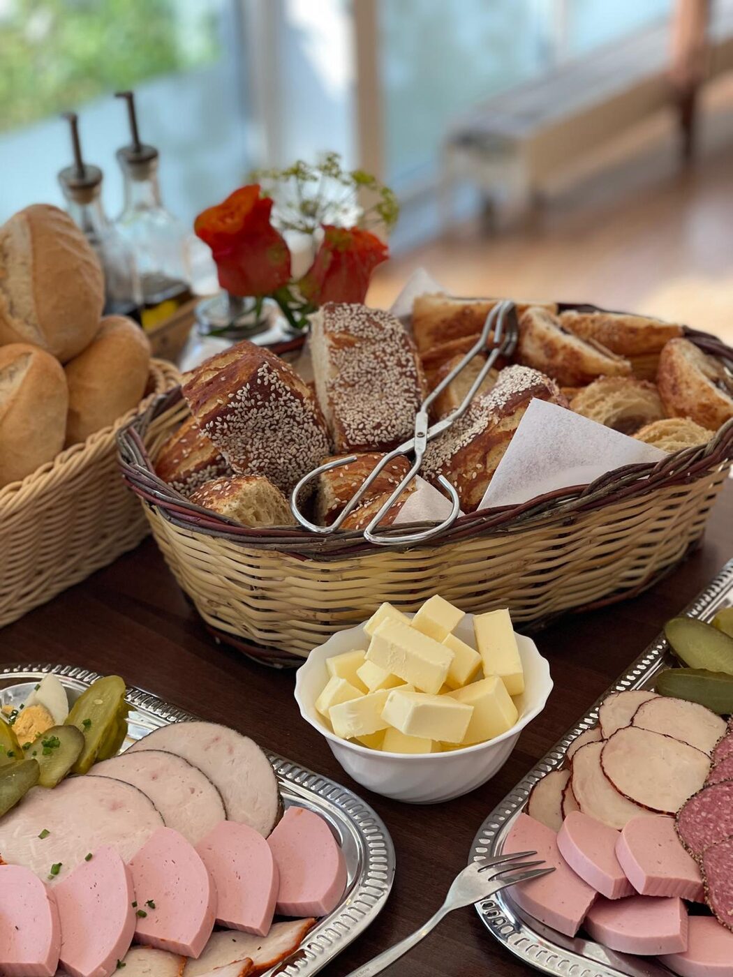 Liebevoll dekoriertes Buffet mit Rosen und Brotkorb